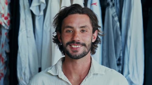 Man smiling in front of wardrobe closet