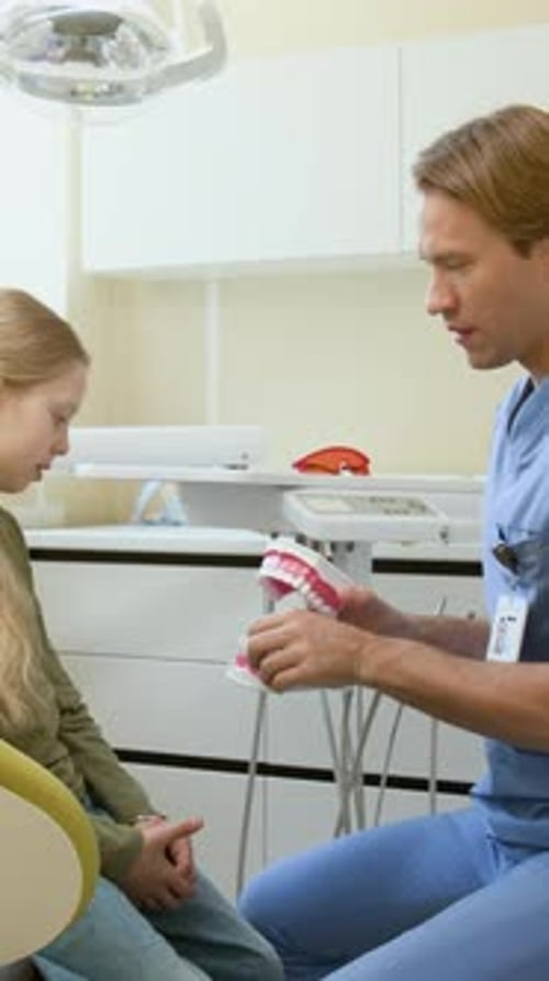 Dentist Shows Child Patient How to Brush Teeth