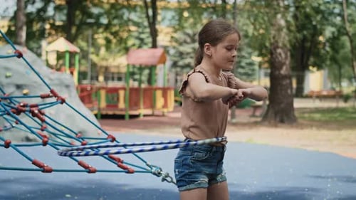 Caucasian girl playing with plastic hop at the playground. Shot with RED helium camera in 8K.