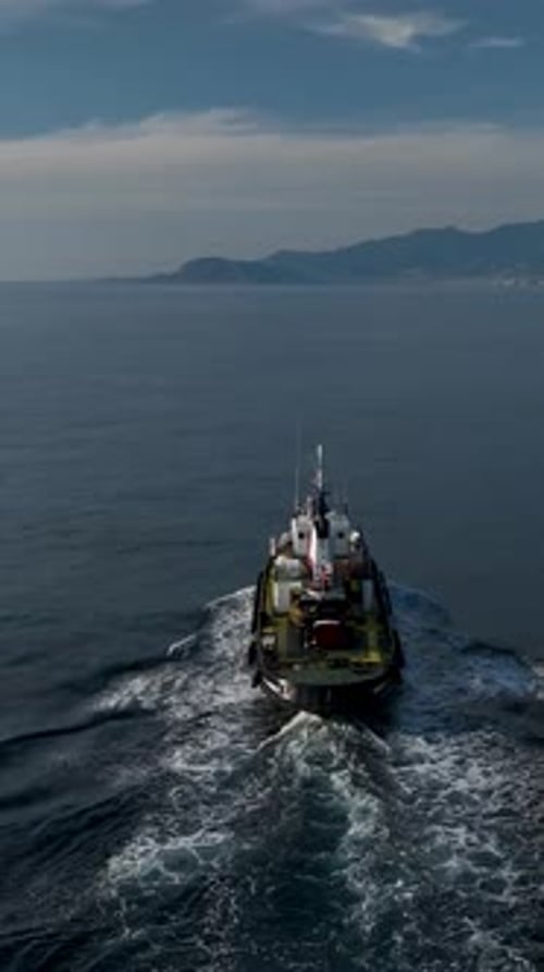 Vertical Video Maritime Majesty Tugboat's Passage on the Azure Sea