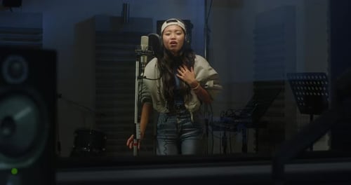 Portrait of a Professional Female Asian Singer Recording a Song in a Studio. Beautiful Y