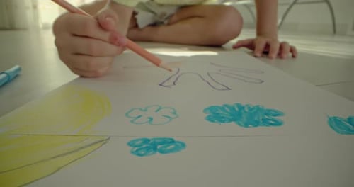 Detailed Shot of Children's Hands Engaged in Colorful Pencil Drawing