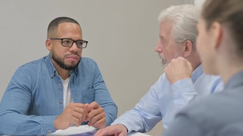 Three People Discussing Business at a Table
