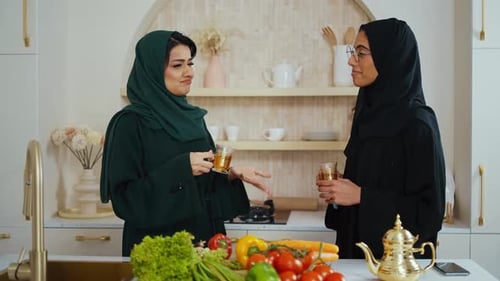 Mulheres muçulmanas tomando chá e conversando na cozinha