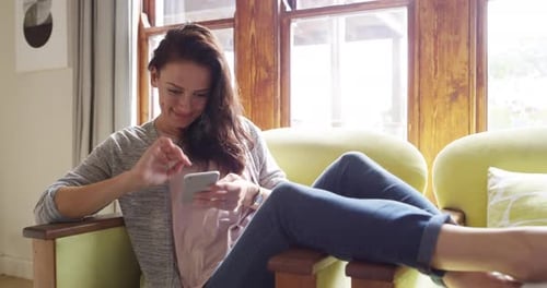 Smiling Woman Using Smartphone by Bright Window