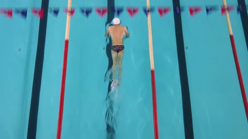 Nadador muscular profesional Hombre nada en la piscina Un atleta masculino nada braza a alta velocidad