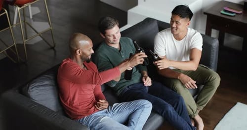 Three friends drinking beer on the couch