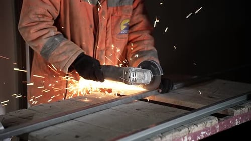 Construction Worker Cutting Metal Bar with Sparks