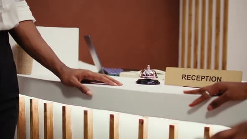 Tourists Ringing Concierge Bell Close Up