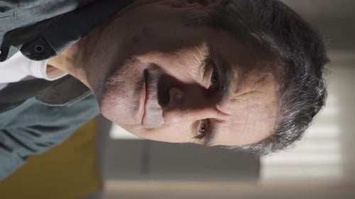 Vertikales Video von allein zu Hause und einem traurigen Mann, der sich nachdenklich umschaut.