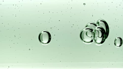 Gel fluide cosmétique transparent avec bulles de molécules et huile circulant dans un tube en verre avec liquide transparent
