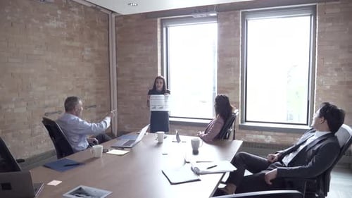 Businesswoman leads multiethnic team meeting with data review in corporate office