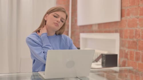 Young Woman with Neck Pain Uses Laptop