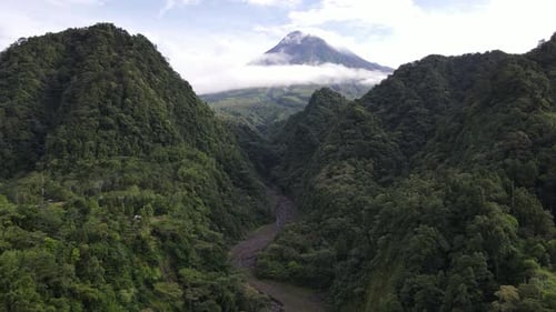 Beautiful view of Mount Merapi in the morning between the green hills. The mountain is in Yogyakara,