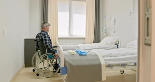 MiddleAged Man in Wheelchair in Hospital Room