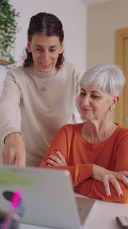 Smiling Women Use Laptop Together Inside a Home