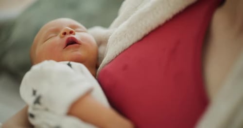 Gentle Mother Holding Newborn Infant in Soft Light