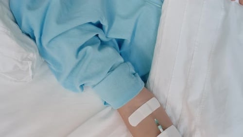 Young Person Resting in Hospital Bed Receiving Treatment