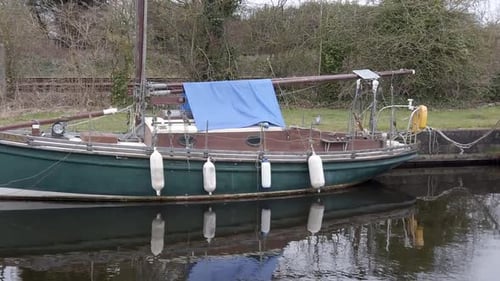 Classic old sailboats moored on narrow rural countryside canal marina