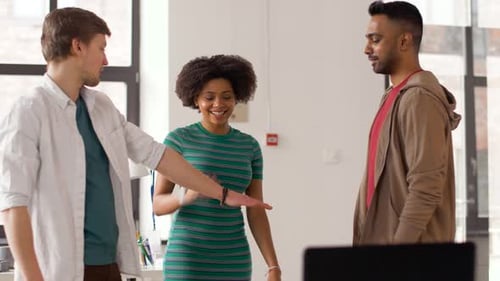 Happy multiethnic business team stacking hands together in modern office