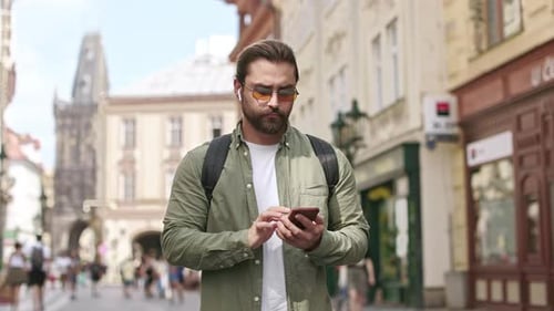 Handsome Brunette Man Standing on Street Holding Using Smartphone