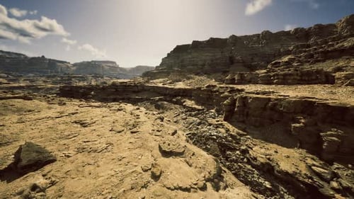 Sunlit Arid Region Featuring Sedimentary Structures and Distant Escarpments