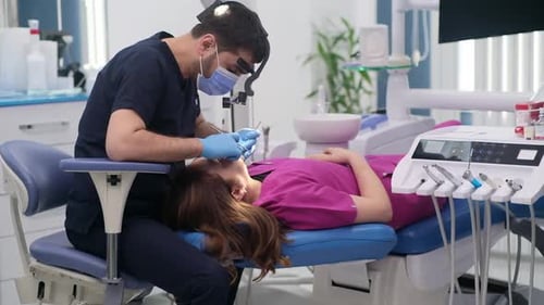 Dentistry Clinic Detailed Checkup of Female Patient on Couch Focused Dentist in Mask Checking Teeth