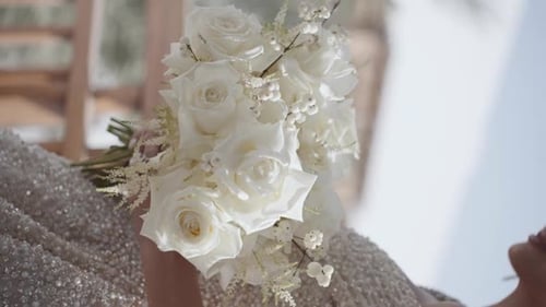 Woman Holding White Rose Bouquet at Wedding