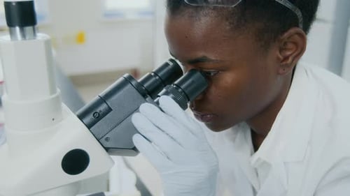 Woman Scientist Using Microscope in Bright Laboratory
