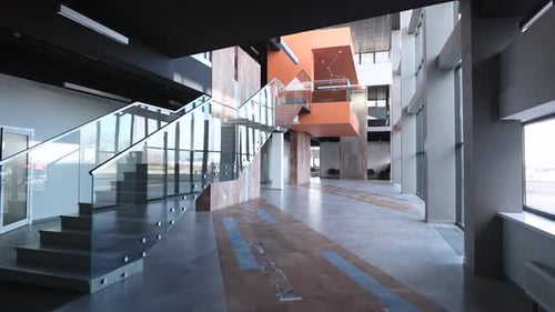 The Camera Pans Across a Spacious and Empty Hall Inside a Modern Office Building The Hall is Filled