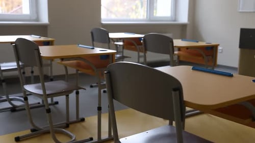 Stylish classroom with desks and chairs at school. Camera moving right