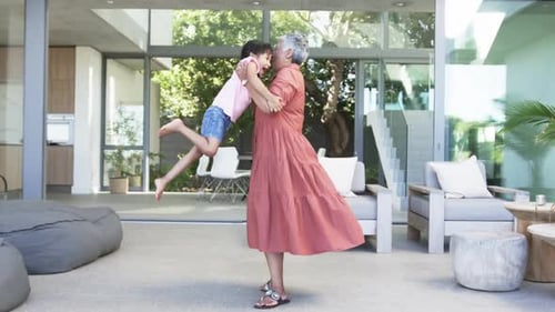 Grandmother Hugging and Spinning Child on Sunny Patio