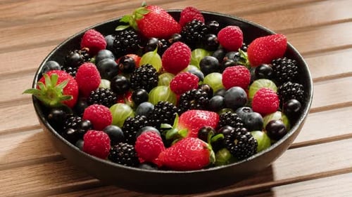 Bowl of Fresh Colorful Mixed Berries on Wood