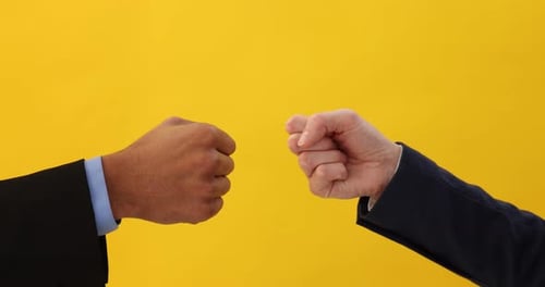 Fist bump gesture between colleagues on yellow background
