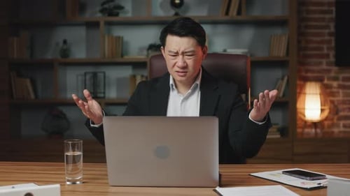 Man Frustrated Working on Laptop Computer in Office