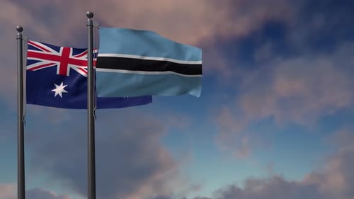 Australian and Botswana Flags Waving on Flagpoles Against Cloudy Sky