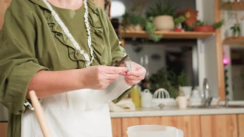 Woman Preparing Pastry Bag in Bright Kitchen
