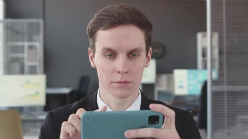 Businessman Using Smartphone in Office