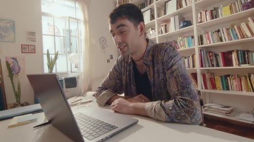 Young Adult Talking on a Laptop Indoors