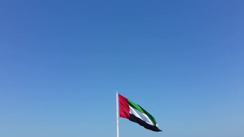 UAE Flag Waves in a Clear Blue Sky