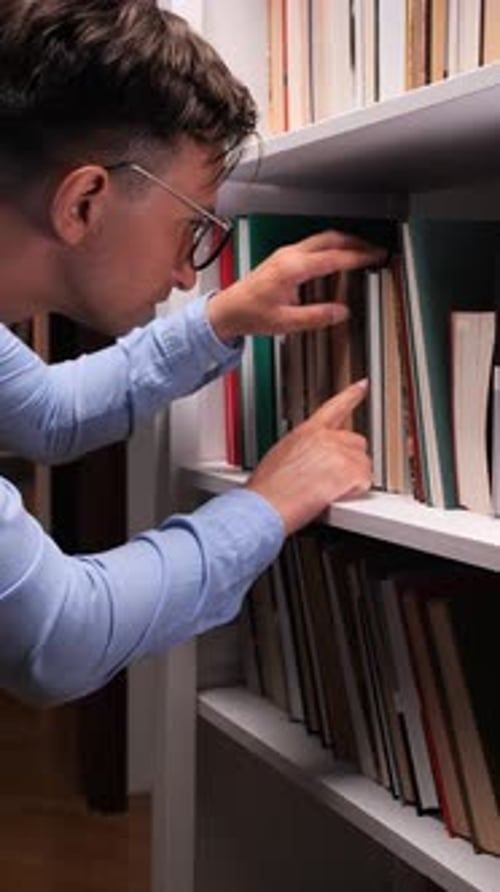 Vertical Video Librarian Searching Books on Bookshelf in Library