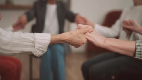 Thérapie de groupe avec des femmes psychologues professionnelles se tenant la main en gros plan, affirmation et méditation