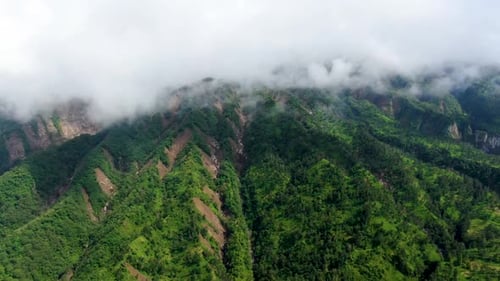 Mount Merapi covered with clouds, Yogyakarta in Indonesia. Aerial drone descending