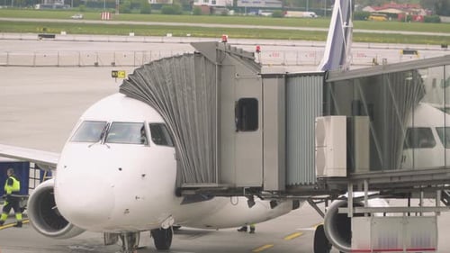 Airplane Parked at Airport with Jet Bridge Connected