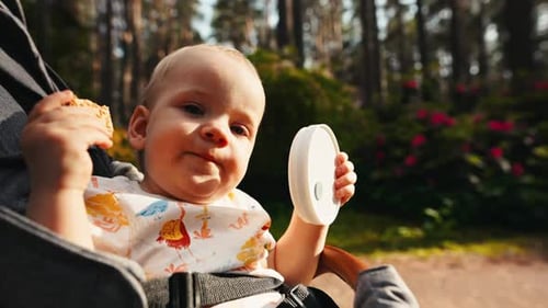 Adorable Infant Eating Snack in Stroller