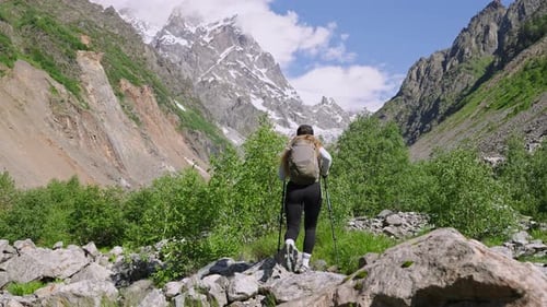 Young Woman Hiking with Backpack in Mountains Female Hiker Walking on Rocky Trail Tourist Girl