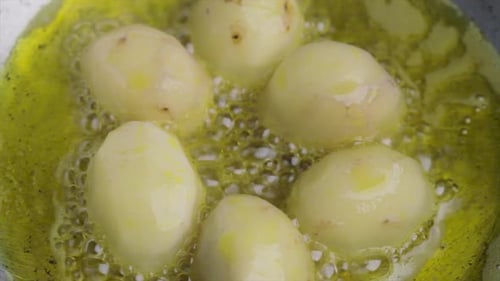 frying raw potato with sizzling hot oil on a pan, cooking potato or vegetables