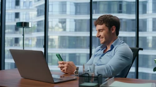 Smiling Man Reading Good News Mobile Phone in Office Closeup. Happy Businessman
