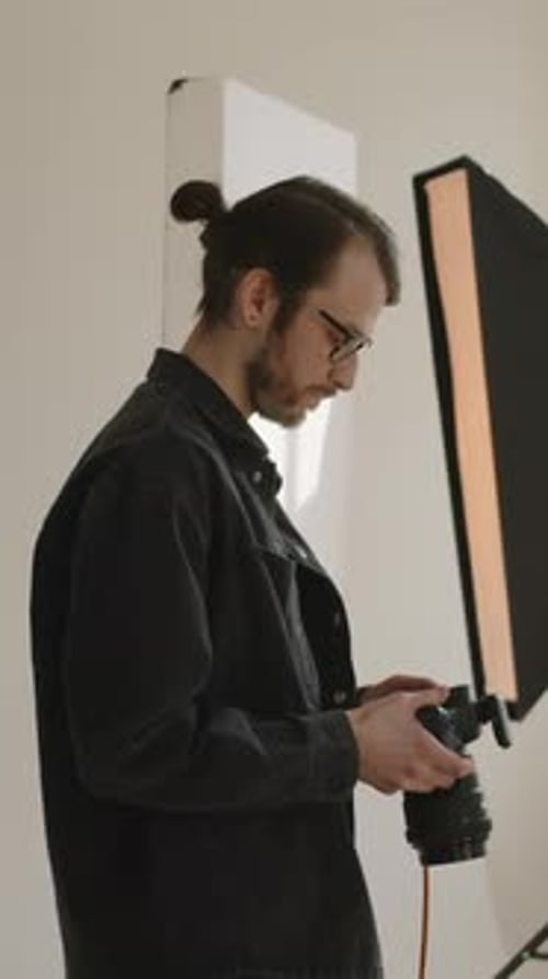 Vertical of Young Photographer Working in Professional Studio