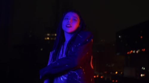 Stylish Woman Dancing in Dark Urban Setting